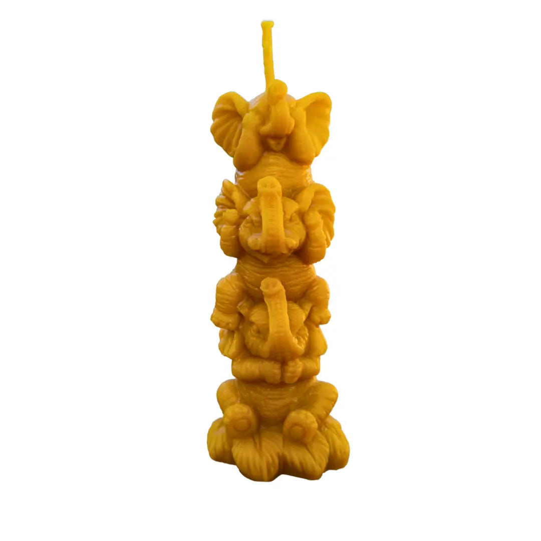 Vela Trilogía Sagrada con tres elefantes simbólicos hecha de cera de abeja sobre fondo blanco