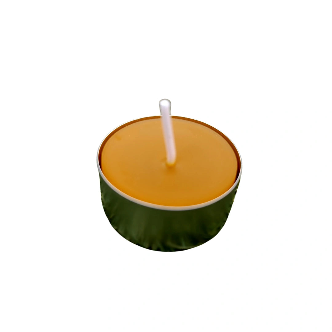 Vela de té natural de cera de abeja con recipiente plateado y mecha de algodón, sin tóxicos ni aditivos.