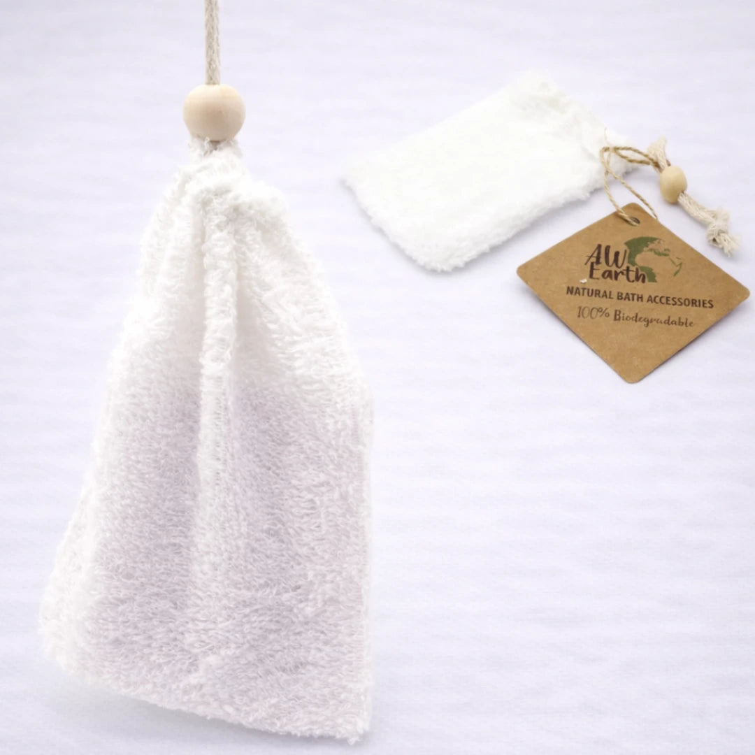 Bolsa exfoliante de bambú colgante biodegradable para jabón sólido con etiqueta natural sobre fondo grisáceo suave