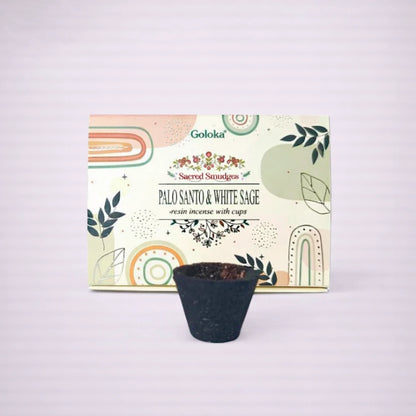 Copa de incienso Goloka Palo Santo y Salvia Blanca con caja Sacred Smudges sobre fondo gris suave