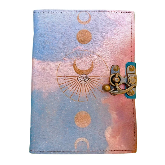 Cuaderno de cuero genuino con diseño celestial de fases lunares doradas y cierre con broche metálico antiguo, perfecto como diario personal o grimorio artesanal.