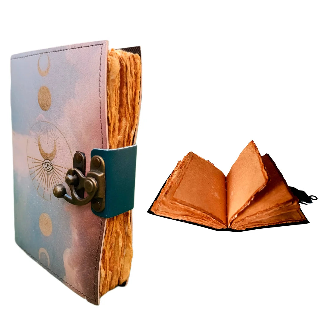Cuaderno de cuero artesanal con fases lunares en dorado, cierre metálico vintage y papel rústico grueso de bordes irregulares, ideal para escritura creativa y espiritual.