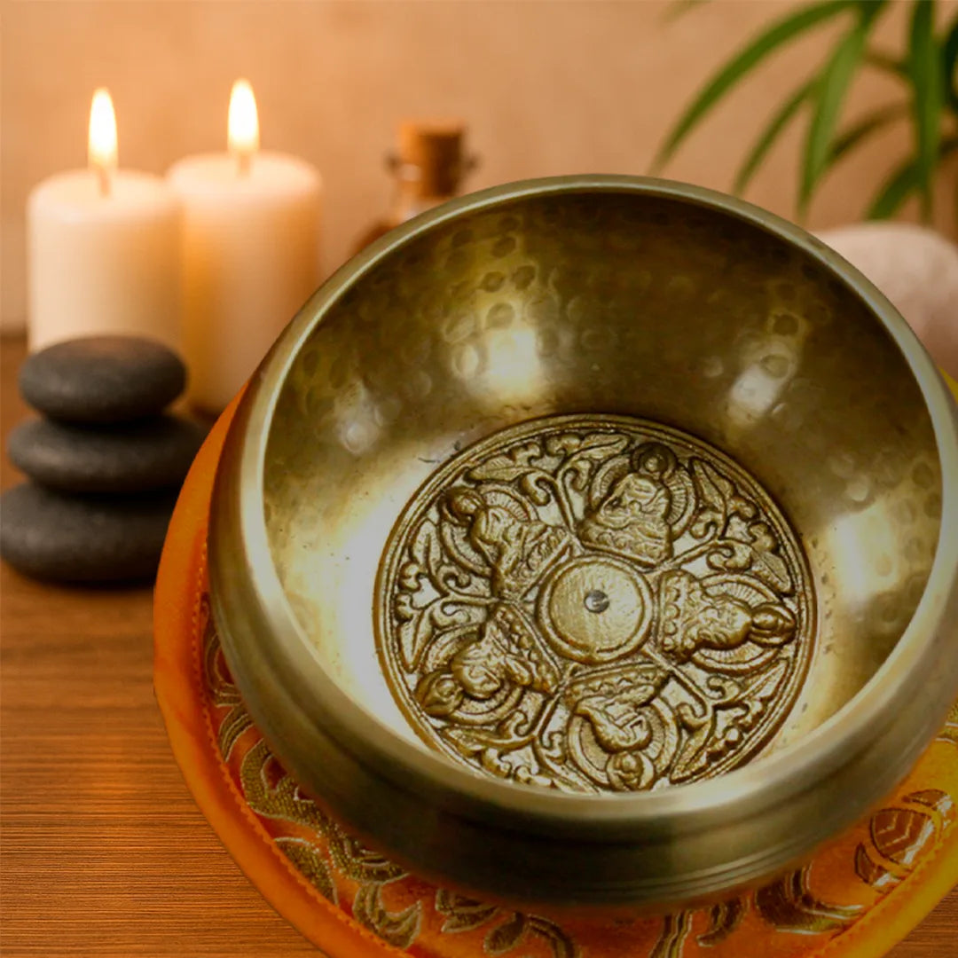 Cuenco tibetano 5 budas en ambiente de relajación con velas, piedras y decoración zen.