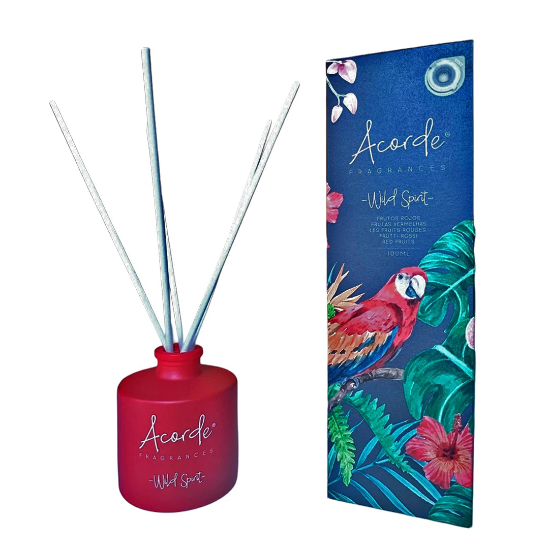 Difusor de varillas Mikado Frutos Rojos con fondo blanco y estuche decorativo con ilustración de papagayo y plantas tropicales.