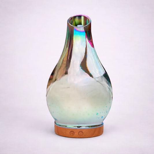 Difusor ultrasónico de aromas Ibiza con diseño iridiscente y base efecto madera sobre fondo gris suave