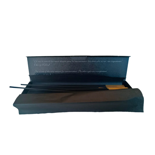 Varillas de incienso afrodisíaco de nuez de macadamia dentro de caja negra abierta, ideal para crear un ambiente íntimo y relajante con aroma cálido y seductor.