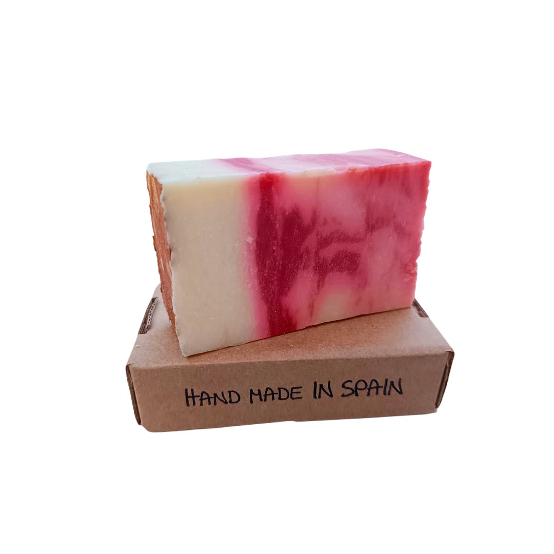 Pastilla de jabón de arcilla roja y rosa colocada sobre caja kraft con texto 'Hand Made in Spain'. Producto natural hecho a mano.