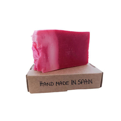 Jabón natural de karité color rosado sobre caja kraft con texto Hand Made in Spain.