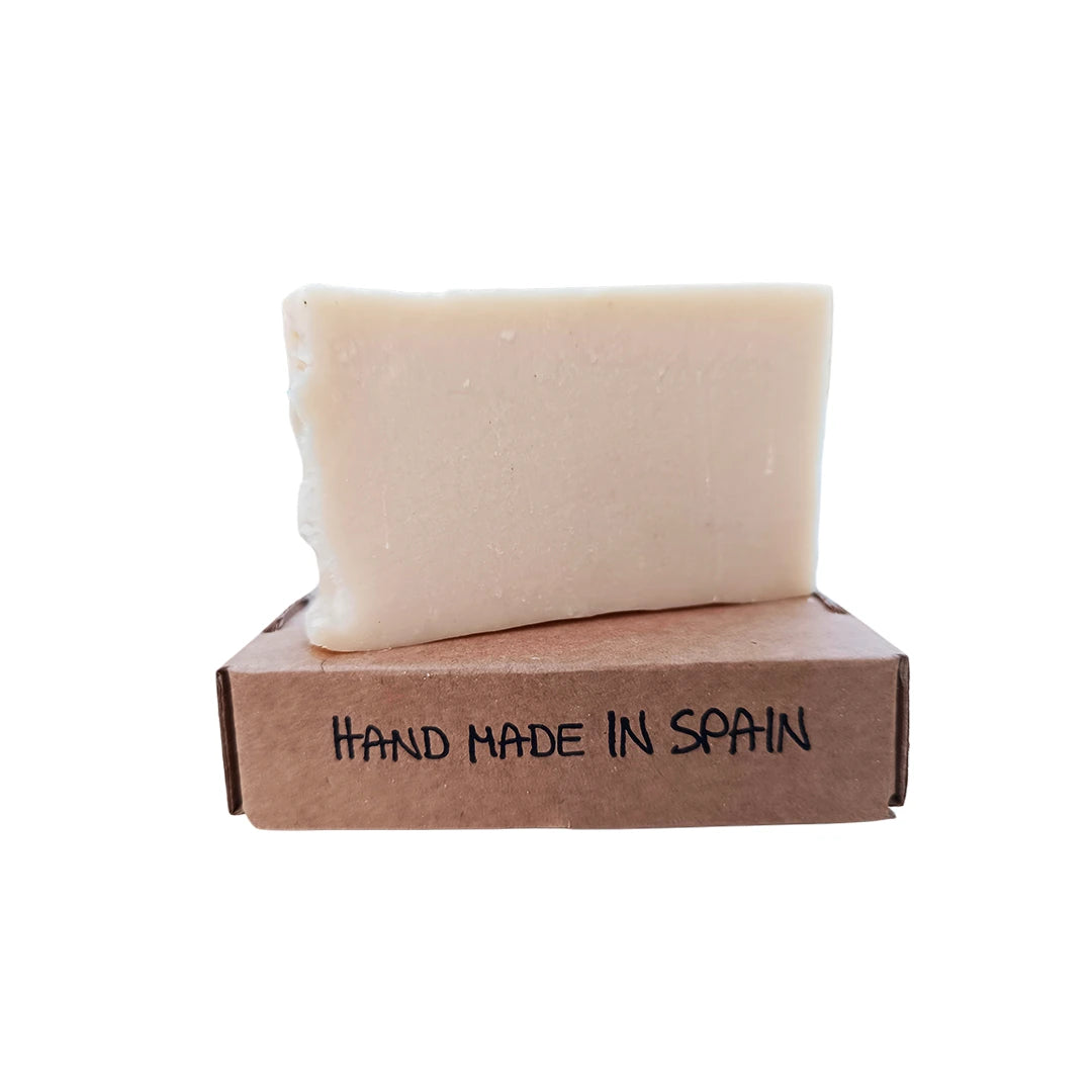 Jabón de leche de burra hecho a mano colocado sobre caja kraft con etiqueta "Hand Made in Spain", cosmética natural artesanal española.
