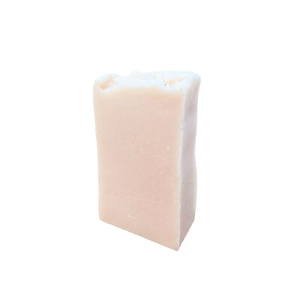 Pastilla de jabón artesanal de leche de burra sobre fondo blanco, color beige claro natural, ideal para pieles secas y sensibles.