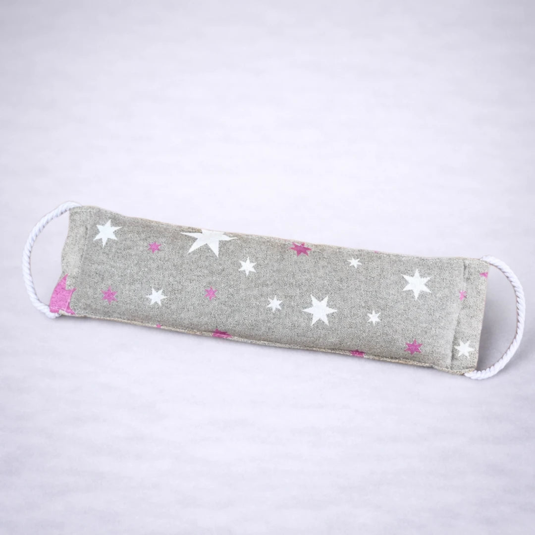 Saco térmico de semillas con estampado de estrellas en tonos neutros, perfecto para relajación y descanso, fotografiado sobre fondo gris suave.