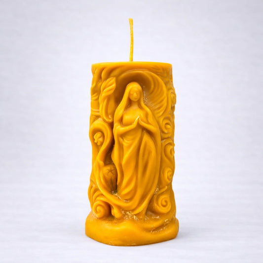 Vela artesanal de cera de abeja Luz Interior con figura femenina en relieve, símbolo de calma y conexión espiritual, sobre fondo gris suave