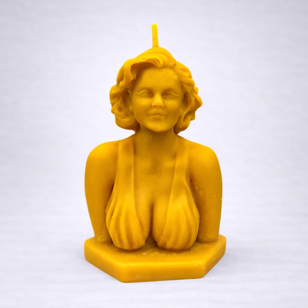 Vela decorativa de cera de abeja inspirada en Marilyn Monroe, con acabado artesanal y fondo gris claro profesional