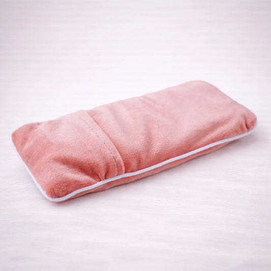 Almohadilla terapéutica de sal del Himalaya con funda suave, ideal para aplicar calor o frío y aliviar dolores musculares y cervicales.