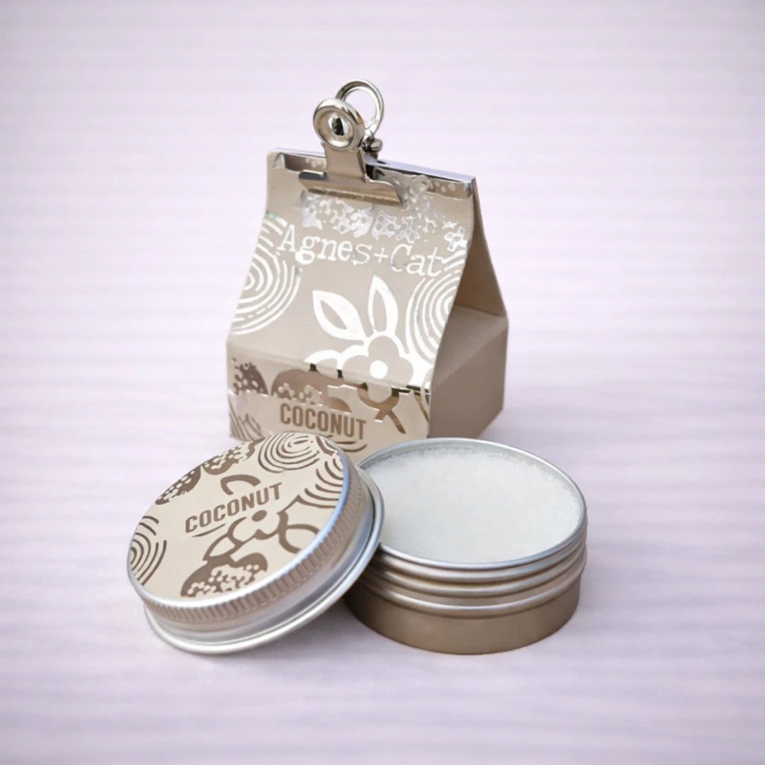 Bálsamo labial natural de coco Agnes + Cat con tarro de aluminio y crema visible sobre fondo neutro