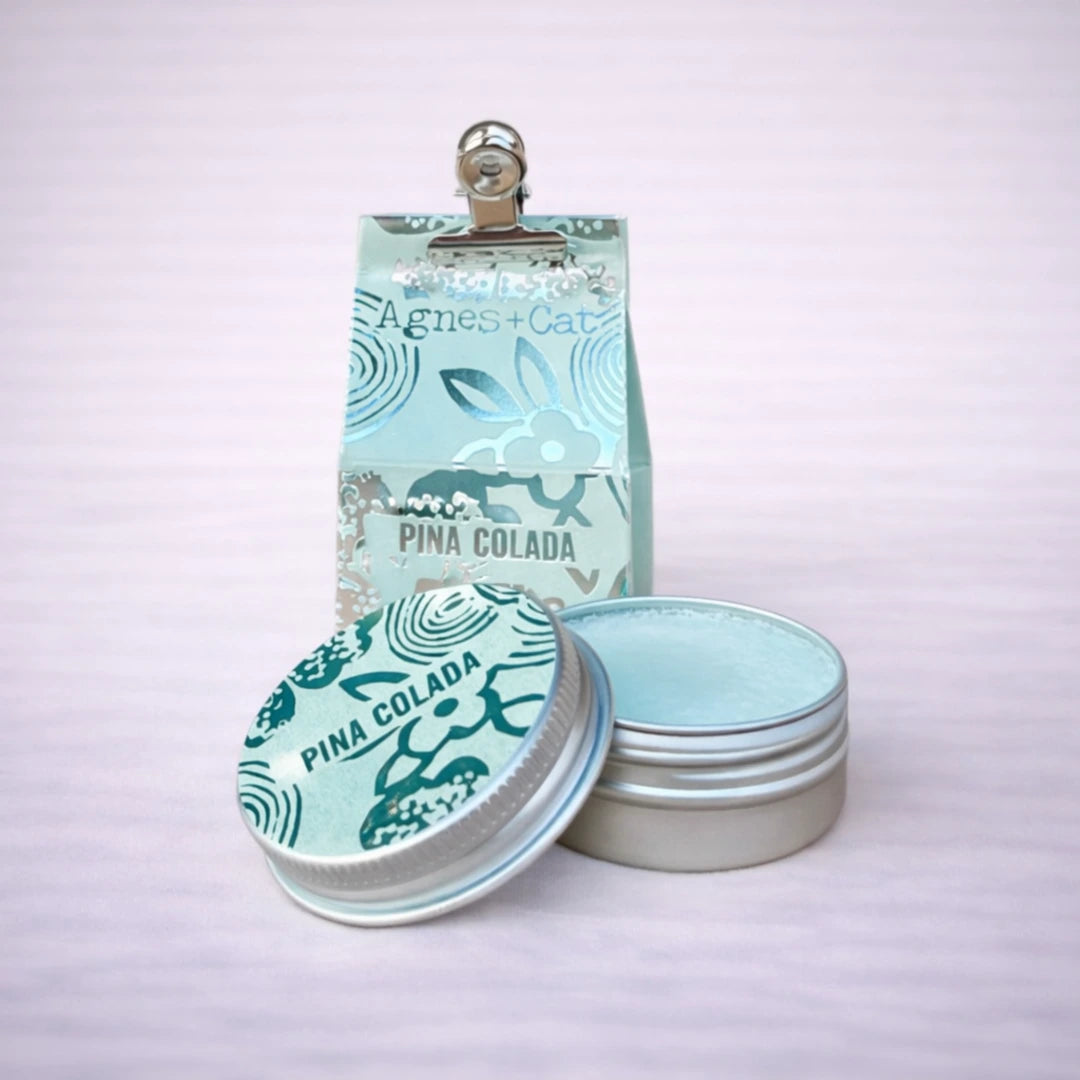 Bálsamo labial natural Piña Colada Agnes + Cat con envase metálico abierto y diseño ilustrado
