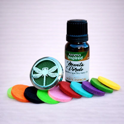 Difusor de aromas para coche con diseño de libélula más un aceite esencial de menta verde y discos de fieltro de colores sobre fondo neutro