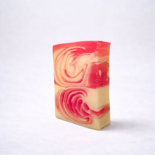 Jabón artesanal de fresa aromático y vegano con diseño marmoleado en tonos rojos y crema