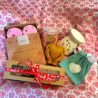 Pack Amor en Calma con vaporizador cerámico con luz, ceras aromáticas en forma de corazón, velas artesanales y accesorios de bienestar sobre fondo romántico