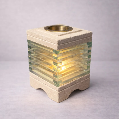 Quemador de aromas Java de vidrio y piedra tallada con cuenco de latón y vela encendida, luz cálida y diseño artesanal