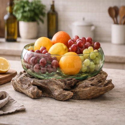 Cuenco de vidrio verde sobre base de madera natural con frutas frescas en cocina