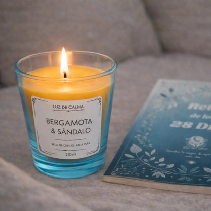 Vela aromática bergamota y sándalo encendida junto a un libro, perfecta para crear un ambiente íntimo, relajante y sensorial en momentos de descanso
