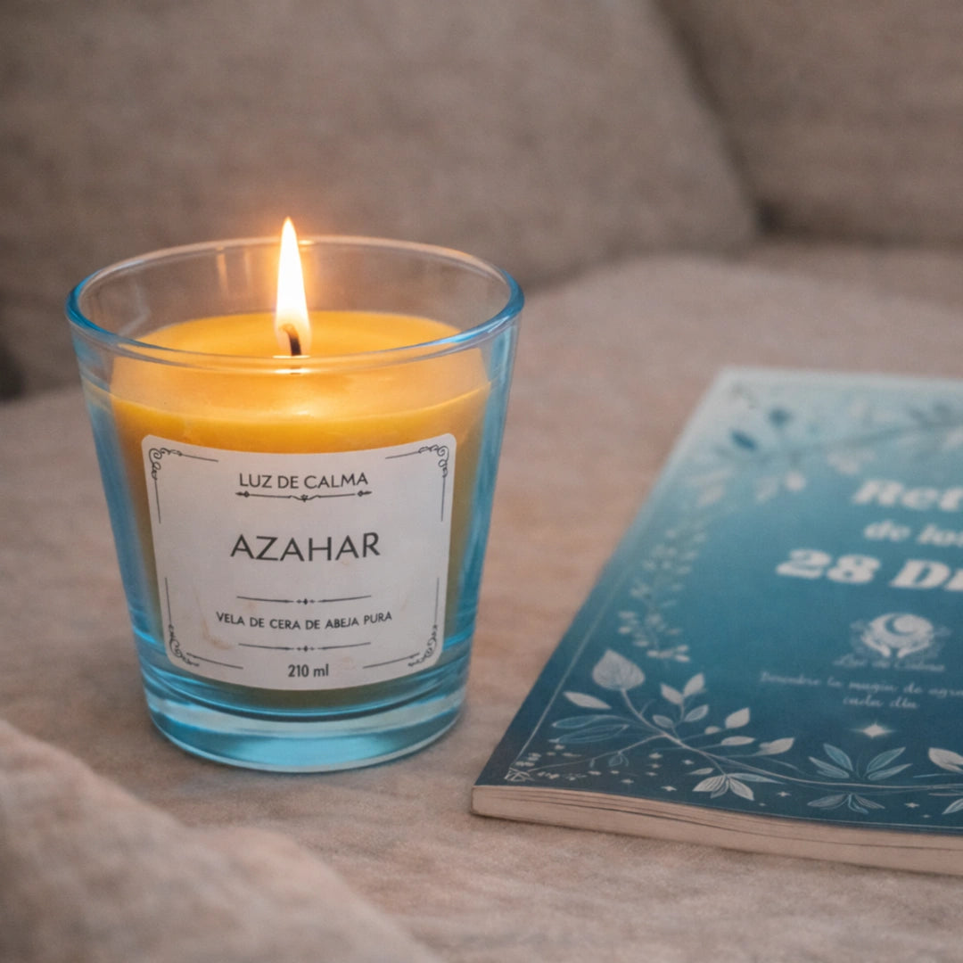 Vela aromática de azahar encendida junto a un libro, creando un ambiente íntimo, relajante y perfecto para momentos de calma en casa