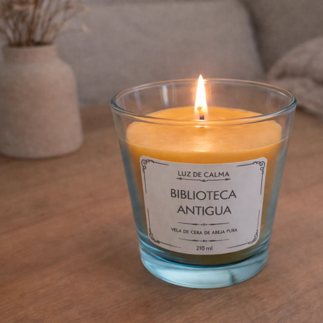 Vela perfumada Biblioteca Antigua encendida sobre mesa de madera, creando un ambiente acogedor, relajante y con esencia cálida tipo biblioteca clásica