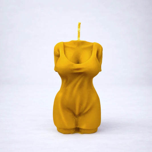 Vela artesanal de cera de abeja con forma de torso femenino, símbolo de feminidad y conexión con el cuerpo